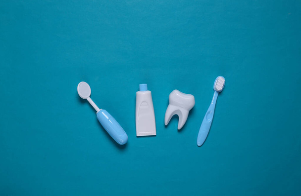 Attrezzatura dentista giocattolo su sfondo blu. Vista dall'alto. Posa piatta - Foto, immagini