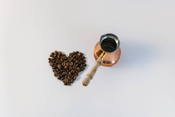 Мідний турк для заварювання кави. Великі ароматичні кавові зерна у формі серця. Любов до ранкової кави. Концепція
 - Фото, зображення