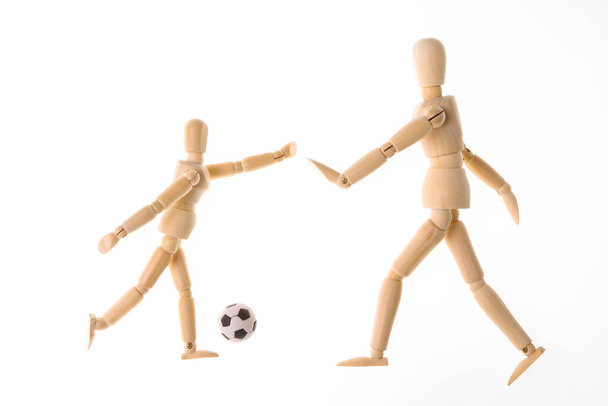Деревянные куклы манекен играть футбол изолированы на белом фоне - Фото, изображение