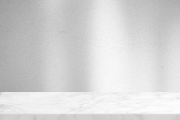 Table en marbre avec fond de texture murale en stuc blanc avec faisceau de lumière et ombre, adaptée à la présentation du produit, à l'affichage et au maquillage. - Photo, image