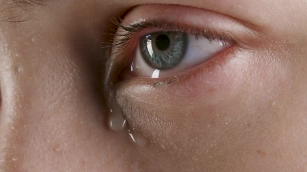 Nahaufnahme eines grauen weiblichen tränenden Auges - Filmmaterial, Video