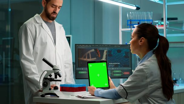 Chemik vědec pomocí zelené maketa obrazovky tablet sedí za stolem - Fotografie, Obrázek