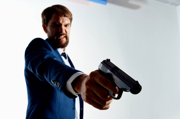 άνθρωπος με κοστούμι κρατώντας όπλο γκάνγκστερ τρόπο ζωής έγκλημα απομονωμένο υπόβαθρο - Φωτογραφία, εικόνα