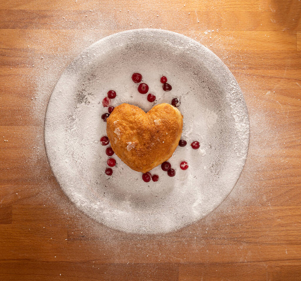 Domowej roboty koncepcja jedzenia. Pączek w kształcie serca na drewnianym stole - Zdjęcie, obraz
