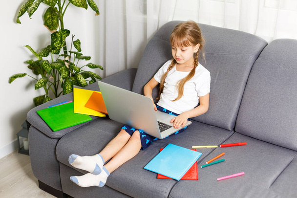 Iskoláslány otthon tanul laptoppal. Otthoni iskola, online oktatás, otthoni oktatás, karantén koncepció - Kép - Fotó, kép