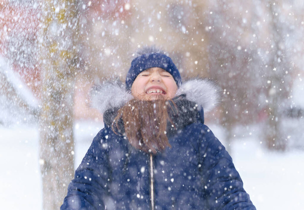 κορίτσι παιδί παίζει με το χιόνι το χειμώνα υπαίθρια και να διασκεδάζουν σε χιονισμένο χειμώνα - Φωτογραφία, εικόνα