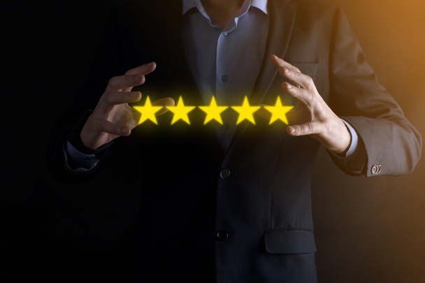 Człowiek ręka pokazując na pięć gwiazdek doskonałe rating.pointing pięć symbol gwiazdy, aby zwiększyć ocenę firmy.Review, zwiększyć ocenę lub ranking, ocena i klasyfikacja koncepcji. - Zdjęcie, obraz
