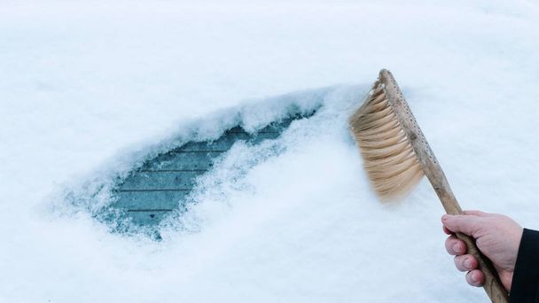 Ручная уборка снега из машины зимой. Транспорт, зима, погода, люди и концепция транспортного средства - Фото, изображение