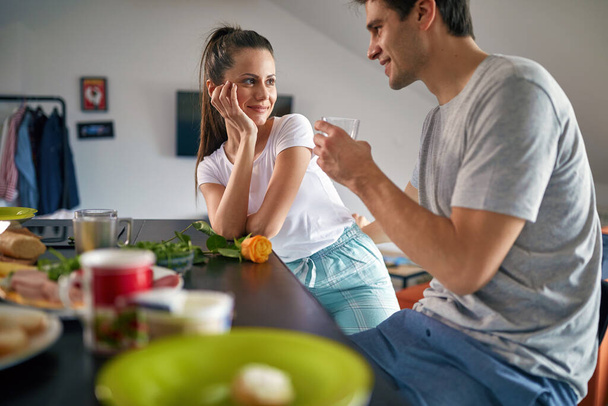 A young couple in a romantic moments while having a breakfast in a relaxed atmosphere at home together. Couple, home, relationship, love - Foto, Imagen