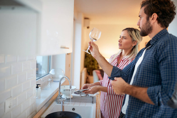 Un jeune couple dans la cuisine aime la propreté de la vaisselle aux détails. Cuisine, ménage, maison, relation - Photo, image