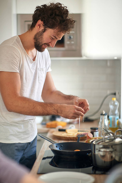 A young guy preparing a meal in the kitchen. Kitchen, food, home, cooking - Foto, Imagem