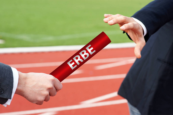Starting the legacy - businessman passes the baton with the German word Erbe  - Foto, afbeelding