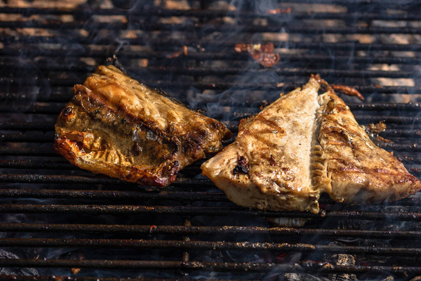 Grilled mackerel fish with smoke on a charcoal barbecue grill. - Foto, afbeelding