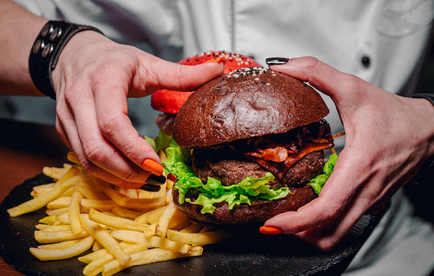 friss finom hamburgert tartó női kezek - Fotó, kép