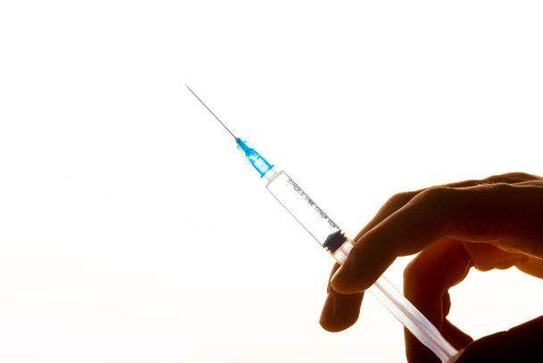 disposable syringe in hand on yellow background, close-up - Photo, Image