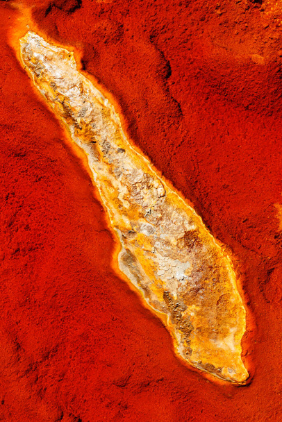Absztrakt textúrák és képződmények az andalúziai Rio Tinto folyó partján. Vörös- és narancssárga, vas és más ásványi anyagok árnyékai a vízben. - Fotó, kép