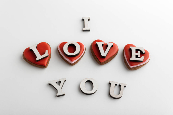 Schriftzug I LOVE YOU und Lebkuchenherzen am Valentinstag. Weißer Hintergrund - Foto, Bild