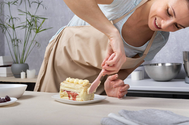 Woman chef prepares cake. Confectionery preparation process. - Фото, изображение