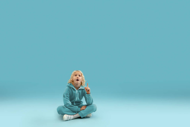 Childhood and dream about big and famous future. Pretty curly boy isolated on blue background - Foto, Bild