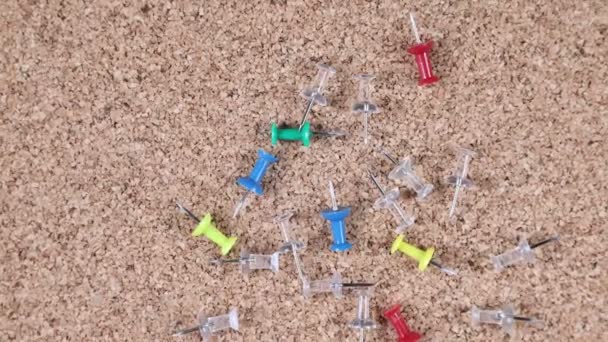 Multicolored scattered tacks on a spinning cork board - Video, Çekim