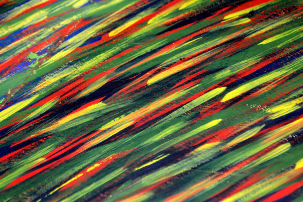 Background from different strokes of red, yellow, green and blue paint with brush close-up. Bright colorful backdrop of colored brush lines. Mixing color streaks of paint with cracked and scratched. - Photo, Image
