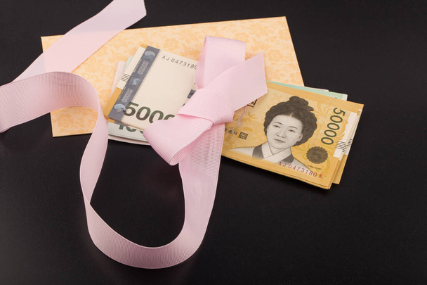 Korea 50.000 won bankbiljet met roze lint op zwart. - Foto, afbeelding