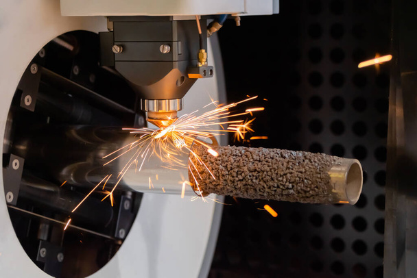 Máquina de corte a laser trabalhando com peça de metal cilíndrico com faíscas - Foto, Imagem