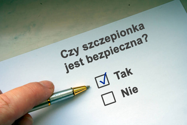 Hand with black pen marking on checklist box. Polish question "Czy szczepionka jest bezpieczna". English: Is the vaccine safe? Coronavirus vaccine concept  - Photo, Image