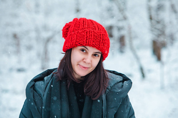 Porträt einer jungen schönen Frau im Winteroutfit inmitten des verschneiten Waldes. - Foto, Bild