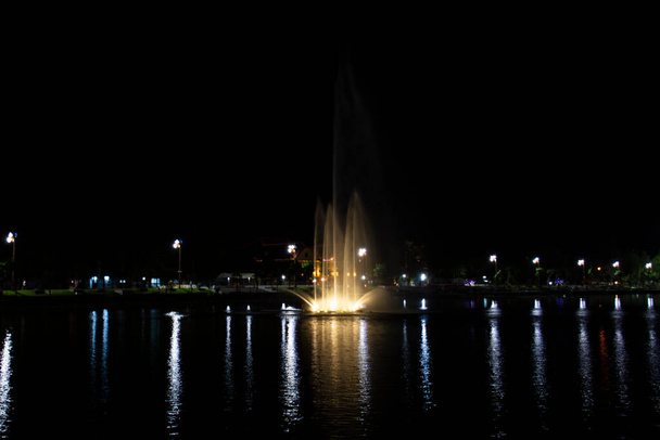Stadtbild Udonthani Stadt und Landschaft Springbrunnen Spray in Teich Nacht für thailändische Menschen reisen Besuch und Ruhe entspannen im Nong Prajak Recreation Centre Public Park in Udon Thani, Thailand - Foto, Bild
