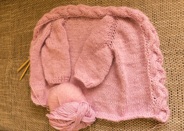 女の子のためのニットジャケット、ピンク色、編み物の質感、手工芸品のコンセプト、手編み、秋の編み時間 - 写真・画像