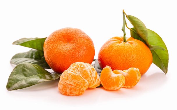 Tangerine levelekkel. Mandarin szeletek. Fehér alapon izolált  - Fotó, kép