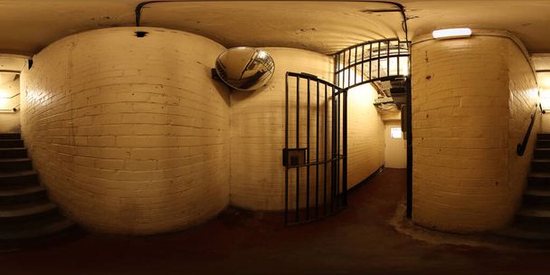 Fotografía panorámica de 360 grados que muestra el interior de una antigua pasarela y escaleras de una celda de prisión histórica - Foto, Imagen