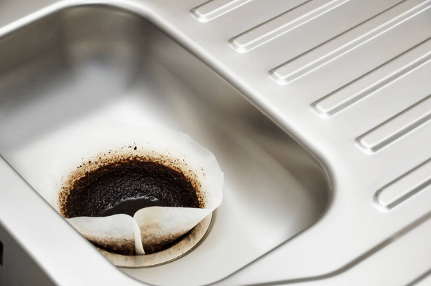 Papier filtre à café drainant dans un trou d'évier de cuisine - Photo, image