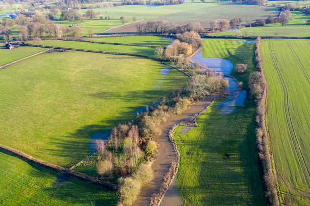 Foto aérea de los campos del campo británico en invierno que muestra un río que ha reventado su orilla para desbordar el agua en los campos, tomada en la ciudad de Wetherby en Yorkshire en el Reino Unido - Foto, imagen