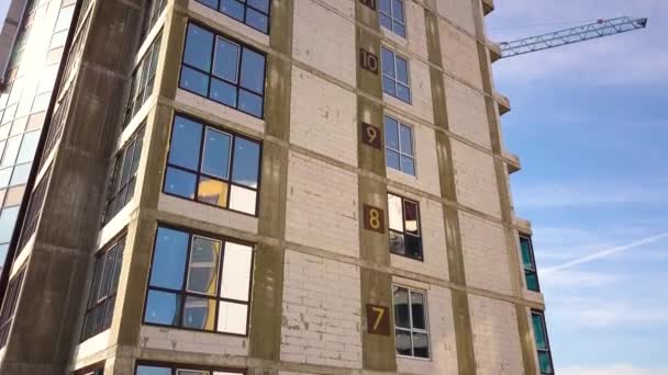 Letecký pohled na vysoký bytový dům s čísly podlaží na zdi ve výstavbě. Nemovitosti development. - Záběry, video