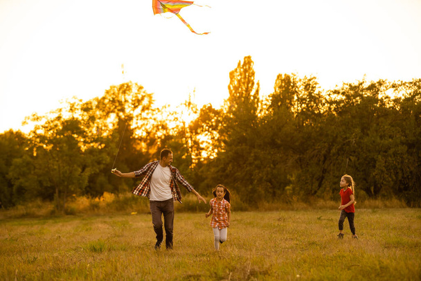 Tata ze swoją córeczką puścił latawiec na pole. - Zdjęcie, obraz