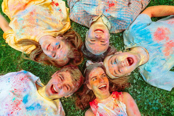 boldog barátok feküdt zöld fű föld piszkos holi festékek - Fotó, kép