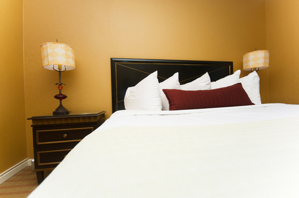 διπλό κρεβάτι στο δωμάτιο του ξενοδοχείου - Φωτογραφία, εικόνα