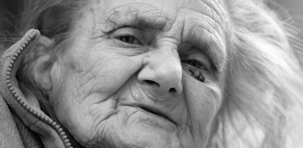 Alte Frau. Porträt einer sehr alten, müden Frau in Depressionen, die drinnen auf dem Bett sitzt - Foto, Bild
