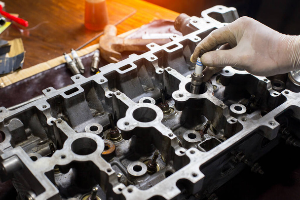 Auto mechanic working in garage. Repair service.  opened automobile engine cylinder head for maintenance repair at car service station for diagnosis - Foto, Imagem