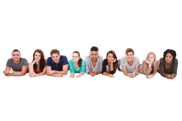 Students Lying In A Row Over White Background - Foto, Imagen