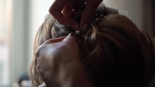 Hairdresser makes a girl's hair. Jewelry for wedding bride - Materiaali, video