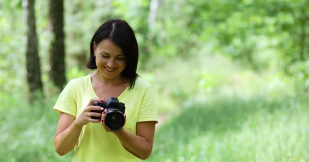 fotógrafa femenina tomar una foto con una cámara profesional al aire libre, - Imágenes, Vídeo
