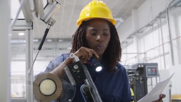 Σίγουρη γυναίκα εργάτης εργοστάσιο παρακολούθησης μηχάνημα με φακό - Πλάνα, βίντεο