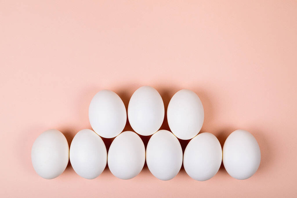 Easter eggs white on a pink background with place for text. Various compositions in a row, top, side, bottom. - 写真・画像