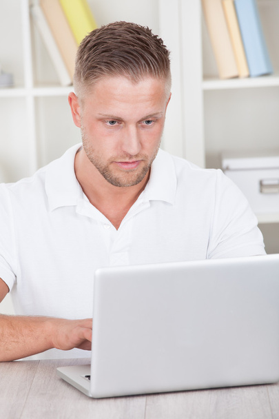 jonge man aan het werk thuis op een laptop - Foto, afbeelding