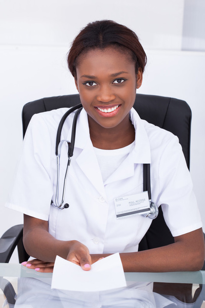 Female Doctor Giving Prescription Paper At Desk - Φωτογραφία, εικόνα