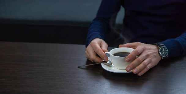 A man at the table with a cup of coffee. Selective focus. Drink. - Foto, immagini