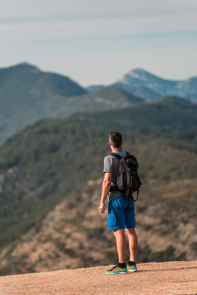 Νεαρός αθλητικός ταξιδιώτης με σακίδιο στέκεται στην κορυφή του όρμου Κότορ (Boka Kotorska), Μαυροβούνιο, Ευρώπη - Φωτογραφία, εικόνα